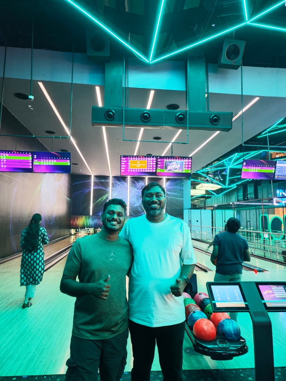 Two men from ECC smiling with thumbs up at the bowling alley